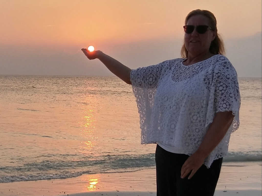 Eine Frau vorm Sonnenuntergang am See